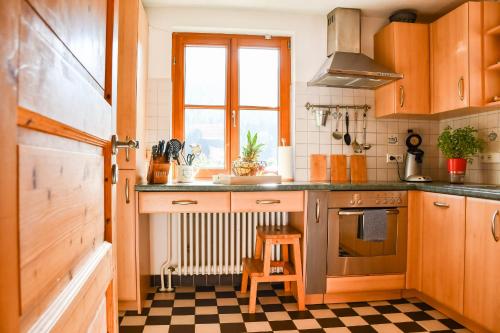 斯堪肯塞尔Ferienhaus Müllerswald的厨房设有木制橱柜和 ⁇ 格地板。