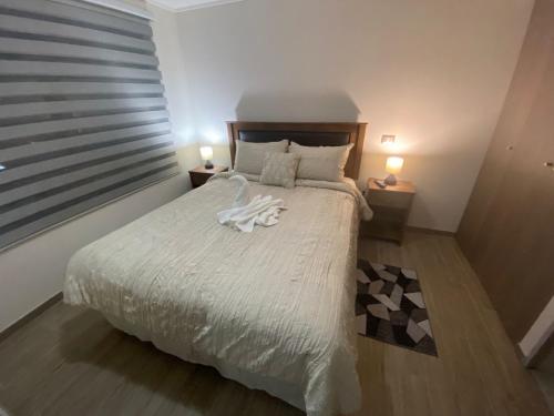 安托法加斯塔Pleno Centro Apart的一间卧室配有一张带两盏灯的大型白色床。