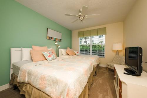 德通纳海滩海岸Unit 103 Opus - 3 Bedroom Ocean Front的一间卧室配有两张床和一台平面电视