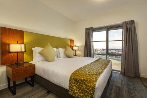 墨尔本墨尔本机场探索公寓的一间设有大床和窗户的酒店客房