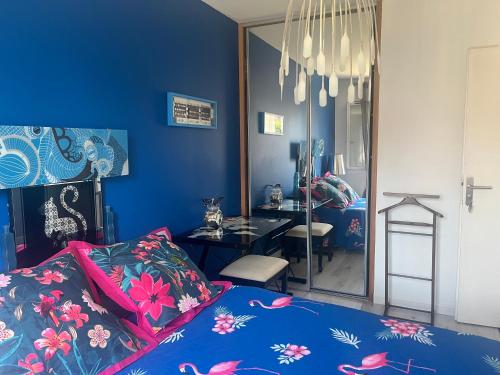 波城ELLO HAPPINESS HOME place to be in pau的一间蓝色卧室,配有一张床和镜子