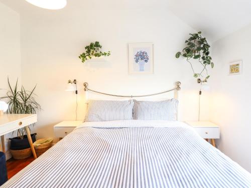 劳斯Rose Cottage的卧室配有白色和蓝色条纹床