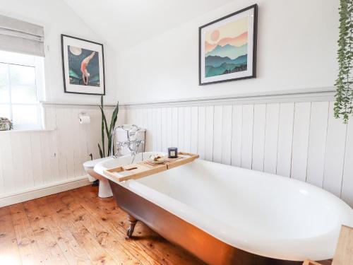 劳斯Rose Cottage的白色客房内的大浴缸,带厕所
