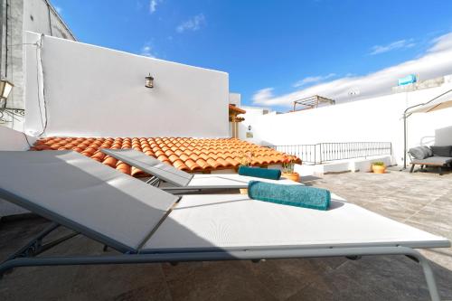 因赫尼奥CASA VERDE Comfortable Air-Conditioned Modern Apartments的房屋屋顶上的长凳
