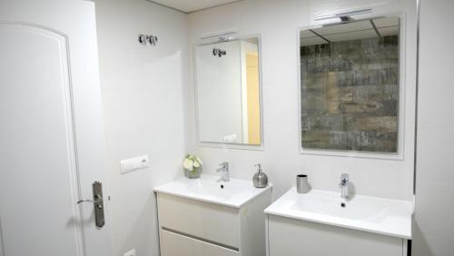 哈恩Slappe Jaén I的白色的浴室设有两个盥洗盆和镜子