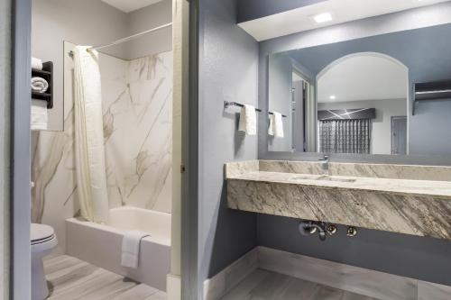 休斯顿美国最佳价值白金套房酒店的一间带水槽、浴缸和卫生间的浴室