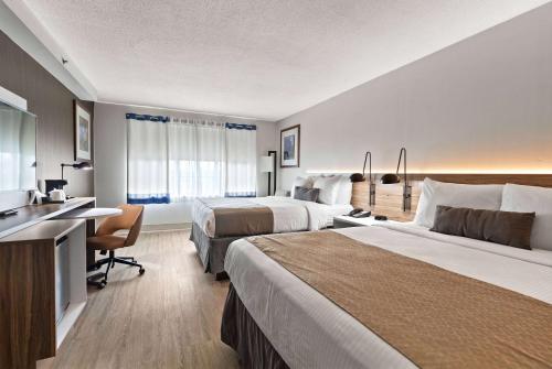 马纳萨斯马纳萨斯温德姆花园酒店的酒店客房配有两张床和一张书桌