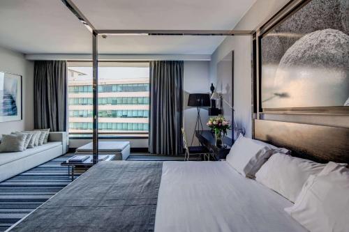 圣地亚哥Wyndham Santiago Pettra的酒店客房设有一张大床和一张沙发。