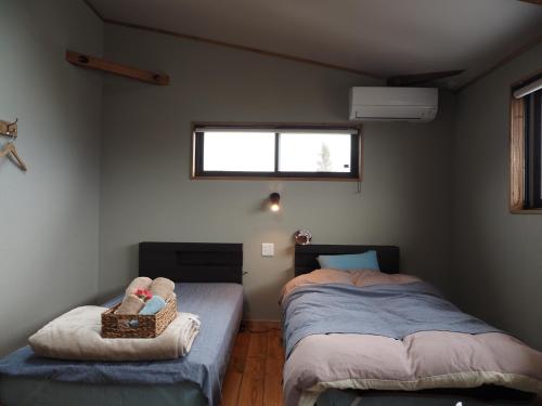 IkedaCANOA GUEST HOUSE A room - Vacation STAY 50937v的一间卧室设有两张单人床和一个窗户。