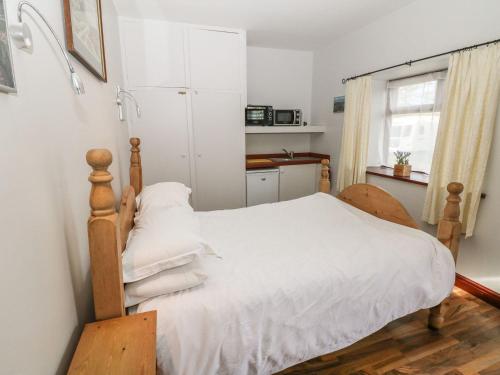 利克Hideaway的一间卧室配有一张带白色床单的床和一扇窗户。