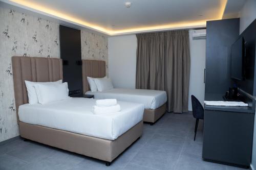 马普托INCANTO RESIDENCIAL的酒店客房设有两张床和电视。