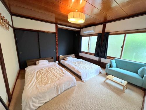 白川村白川乡家族旅馆的带窗户的客房内配有两张床和一张沙发