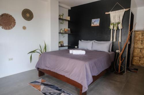 卢纳将军城Happiness Beach Resort Siargao的一间卧室配有一张黑色墙壁的床