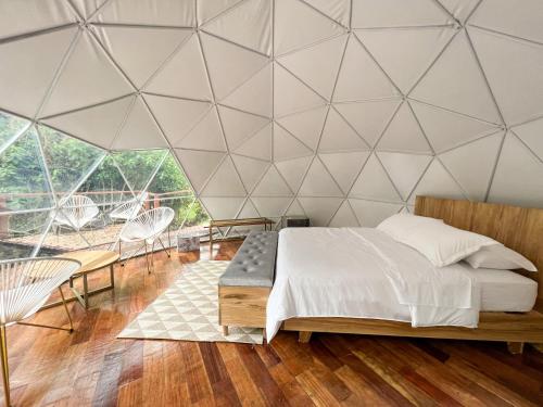 VillamaríaNazca Glamping的一间卧室设有一张床和三角形墙