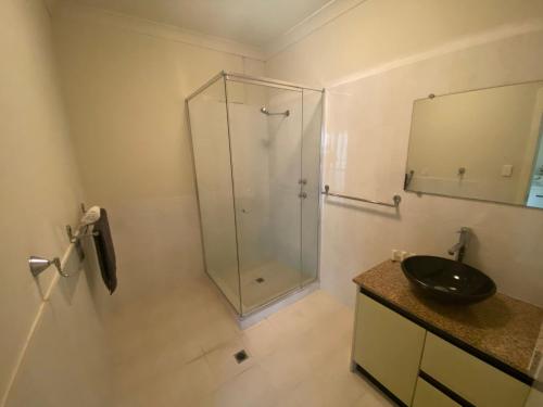 朱里恩湾Unit 46 Seafront Estate的一间带玻璃淋浴和水槽的浴室