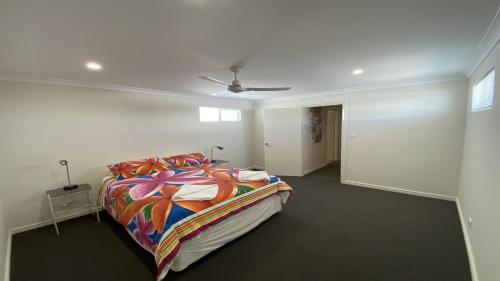 朱里恩湾Unit 54 Seafront Estate的一间卧室配有一张带五颜六色棉被的床