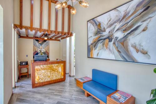 巴亚尔塔港Casa Nicole Boutique Hotel的客厅配有蓝色的沙发和墙上的绘画