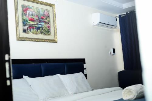 拉各斯Mariners Suites Lagos的墙上照片的一张床位