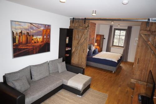 吕本斯普林华德蓝色花园公寓的客厅配有沙发和1张床