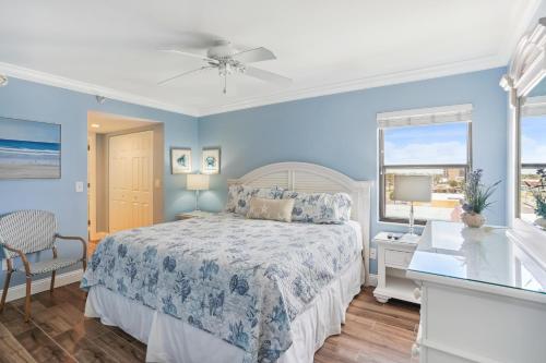 圣徒皮特海滩Emerald Isle 401 - Premier的蓝色的卧室设有床和窗户