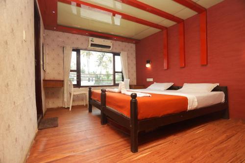 阿勒皮JCT Houseboat的一间卧室设有一张带红色墙壁的大床