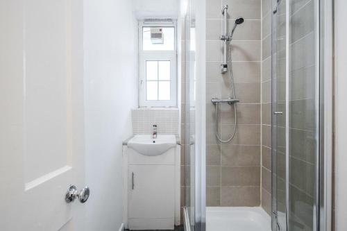 伦敦APlaceToStay Central London Apartment, Zone 1 WAT的带淋浴和盥洗盆的白色浴室