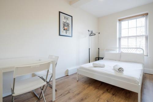 伦敦APlaceToStay Central London Apartment, Zone 1 WAT的白色卧室配有书桌和床