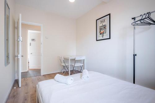伦敦APlaceToStay Central London Apartment, Zone 1 WAT的白色卧室配有床和桌子