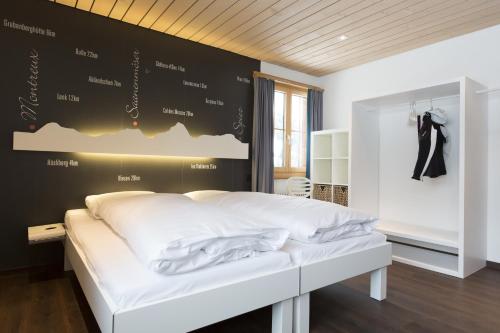 格施塔德博蒂赫莱斯酒店的卧室配有一张白色的床和黑色的墙壁