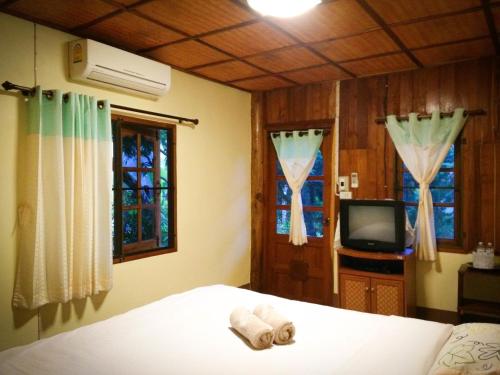 湄宏颂桑萨旺度假酒店的一间卧室设有一张床、一台电视和窗户。