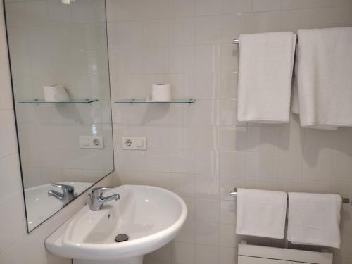 卢戈Hospedería San Froilan的浴室配有盥洗盆、镜子和毛巾