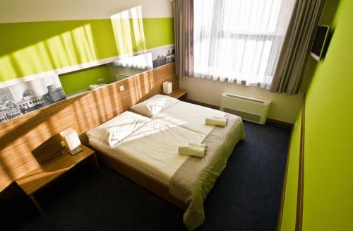 科希策Hotelík Košice的一间位于绿色客房内的卧室,配有一张床