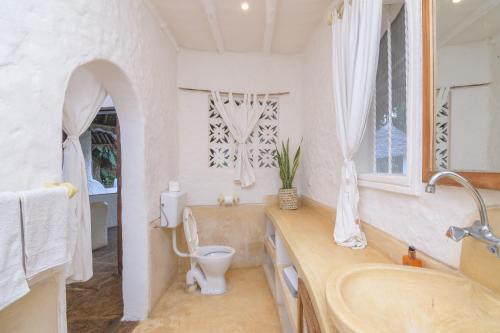 马林迪Peponi Villa Malindi的白色的浴室设有卫生间和水槽。