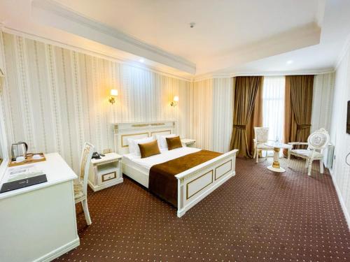 巴库Premier Palace Baku的酒店客房设有一张大床和一张书桌。