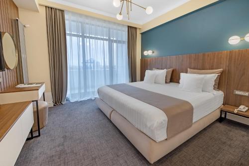 马马亚Hotel Oxford的一间卧室设有一张大床和一个大窗户
