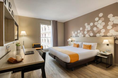 巴塞罗那巴塞罗那馨乐庭兰布拉酒店的配有一张床和一张书桌的酒店客房