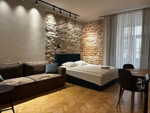 卢布林Apartamenty Rynek 5的一间卧室配有床、沙发和砖墙