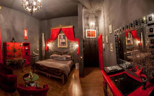 瓦雷泽奥兹共和国客房旅馆的一间卧室配有一张带红色窗帘的床和一张沙发