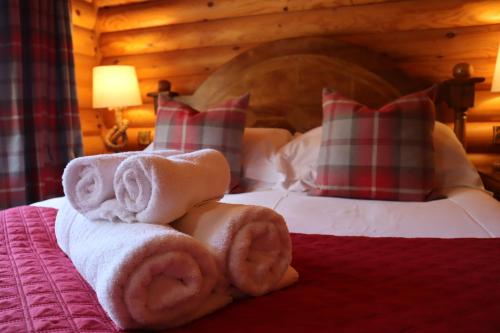 特维德上游的贝里克Bunnahahbain - Two Bedroom Luxury Log Cabin with Private Hot Tub的配有毛巾和枕头的床的酒店客房