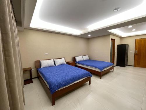 台南新兴九洲会馆 的一间医院房间,配有两张带蓝色床单的床