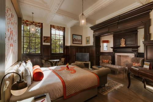 伦敦The LaLit London - Small Luxury Hotel of the World的一间卧室设有一张床,客厅设有壁炉。