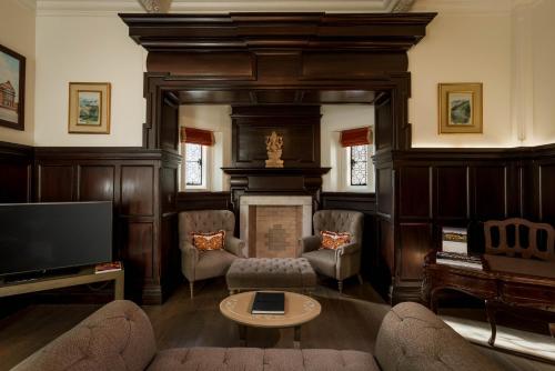 伦敦The LaLit London - Small Luxury Hotel of the World的客厅设有壁炉和电视。