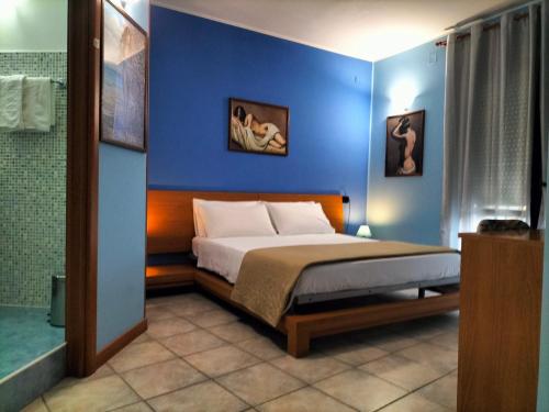 RipalimosaniB&B Le Quercigliole的一间卧室设有一张床和蓝色的墙壁