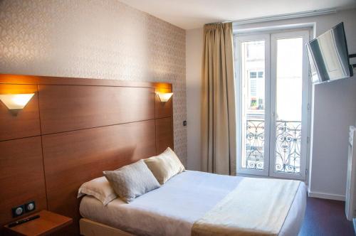 勒布伊The Originals City, Hôtel Bristol, Le Puy-en-Velay的酒店客房设有床和窗户。