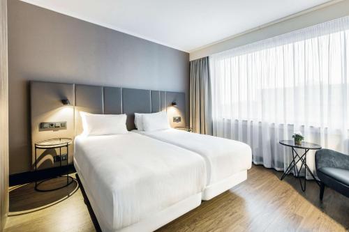迭戈姆NH布鲁塞尔机场酒店的卧室设有一张白色大床和一扇窗户。