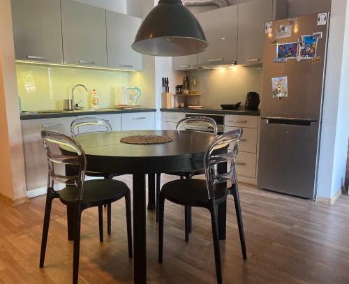 弗罗茨瓦夫Dyrekcyjna Apartment的厨房配有桌椅和冰箱。