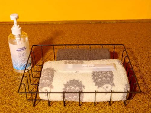 富士宫市Guesthouse TOKIWA - Vacation STAY 01074v的旁边装有一瓶洗涤剂的洗衣篮
