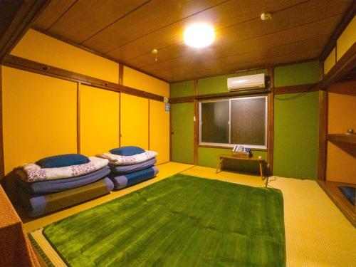 富士宫市Guesthouse TOKIWA - Vacation STAY 01079v的一间设有两张沙发和绿色地毯的房间