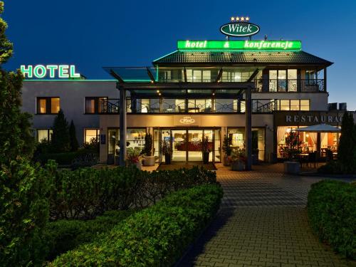 姆德尼擦Hotel Great Polonia Kraków Airport - Ex Hotel Witek的夜间有灯光标志的酒店大楼