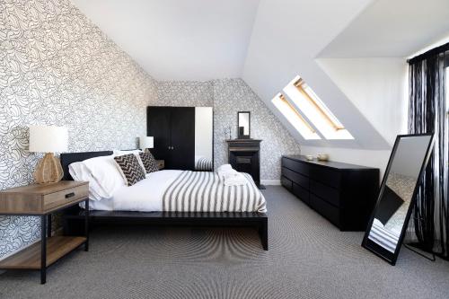 爱丁堡JOIVY Delightful 4-bed house with parking的一间卧室配有一张床和天窗